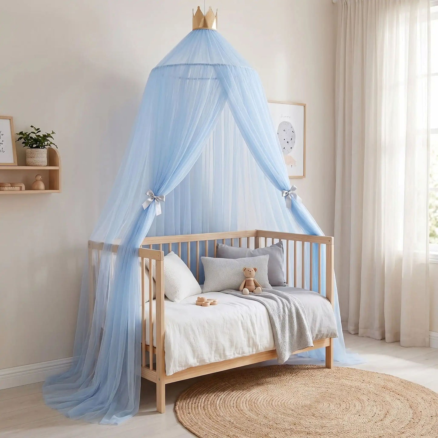 Ciel de lit bébé bleu installé au‑dessus d’une berceau en bois clair dans une chambre cocooning.