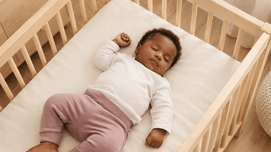 Bébé endormi paisiblement dans un lit en bois clair, illustrant une approche douce inspirée de la méthode 5‑10‑15.