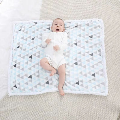  Bébé allongé sur couverture bébé moelleuse design triangles apaisants.
