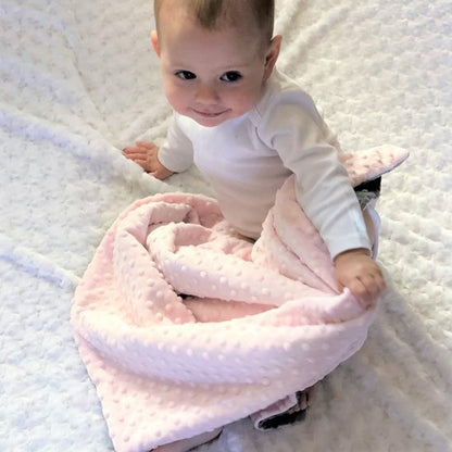 Bébé assis enveloppé dans couverture bebe rose douce et cosy