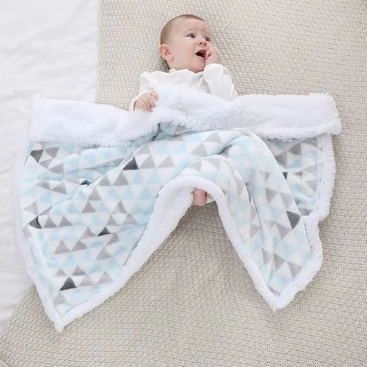 Bébé reposant sous couverture bébé douce géométrique bleu, blanc, gris moelleuse.