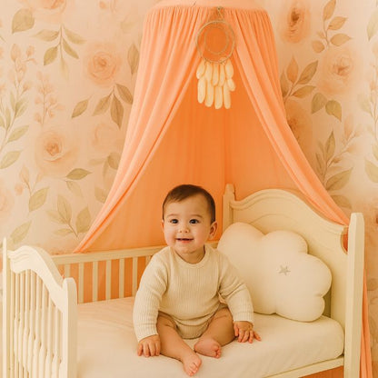 Bébé heureux sous ciel de lit pêche, chambre bohème douce et naturelle.