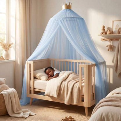 Ciel de lit bleu avec couronne dorée au‑dessus d’une berceau en bois où un bébé dort paisiblement.