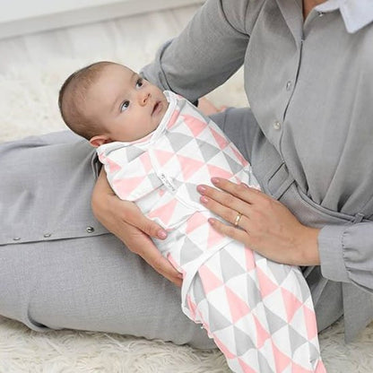 Couverture d’emmaillotage rayures rose gris bébé tenu avec douceur.