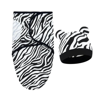 Couverture emmaillotage zèbre avec bonnet assorti présentée ensemble soigneusement.