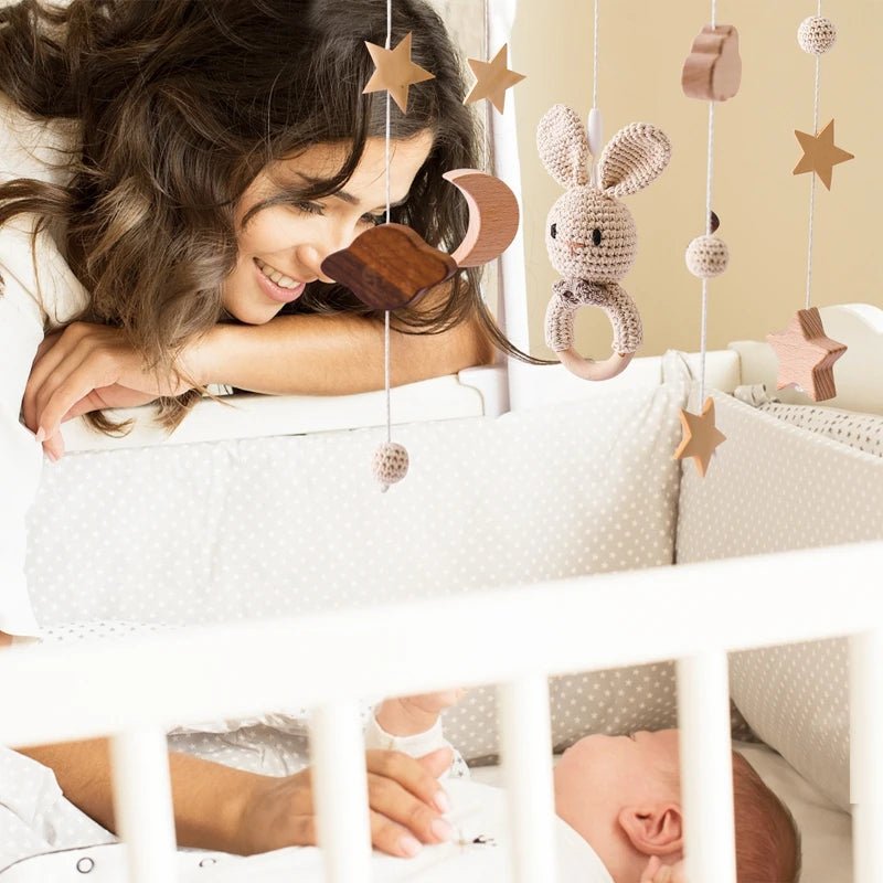 Mobile bébé crochet neutre avec étoiles, lune et maman souriante.