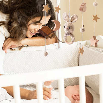 Mobile bébé crochet neutre avec étoiles, lune et maman souriante.