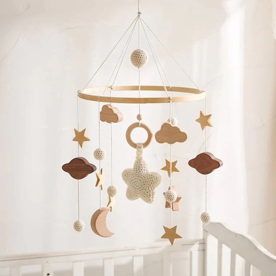 Mobile bébé en bois avec étoiles blanche et nuages suspendus.
