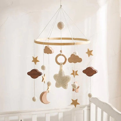 Mobile bébé en bois avec étoiles blanche et nuages suspendus.