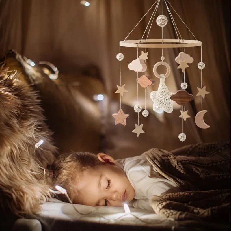 Mobile bébé suspendu apaisant l’enfant endormi sous lumière douce chaleureuse.