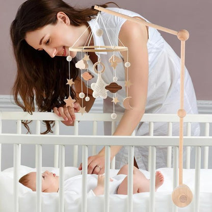 Mobile bébé suspendu au-dessus du berceau, maman regardant tendrement bébé.