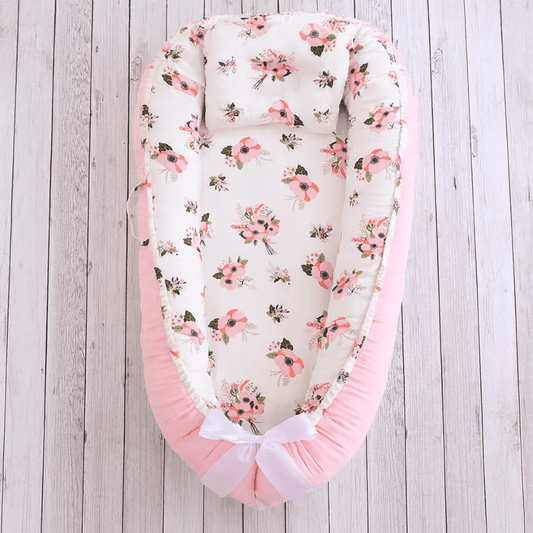 Réducteur de lit évolutif Rosée de Rêve, motif floral pastel, ruban blanc et coussin naissance.
